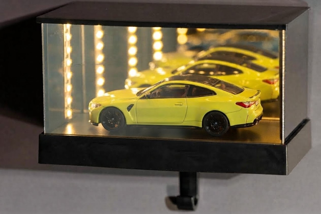 Vitrine vue de trois quarts : la miniature se répète dans les miroirs